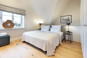 una camera da letto con un letto con lenzuola bianche e una finestra di Strandhafer a List