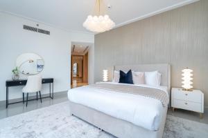 a bedroom with a large white bed and a desk at Vogue Vacation Homes, Downtown Opera Grand near Burj Khalifa and Dubai Mall, Two Bedroom Apartment with Large Balcony and Access to all Amenities in Dubai