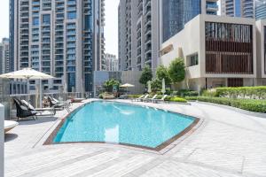 a swimming pool in a city with tall buildings at Vogue Vacation Homes, Downtown Opera Grand near Burj Khalifa and Dubai Mall, Two Bedroom Apartment with Large Balcony and Access to all Amenities in Dubai