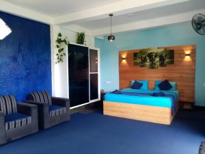 een slaapkamer met een bed en twee stoelen bij Off grid Ella Homestay in Ella