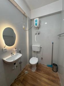 een badkamer met een toilet, een wastafel en een tv bij WeHymn Homes 607 in Gomti Nagar
