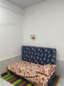 a bed in a room with a pillow on the floor at Golden Wave Cottage in Revadanda