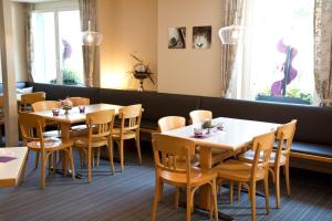 uma sala de jantar com mesas, cadeiras e janelas em Hotel Buchserhof em Buchs
