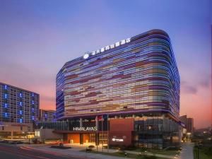 um grande edifício numa cidade ao pôr do sol em Himalayas Qingdao Hotel em Qingdao
