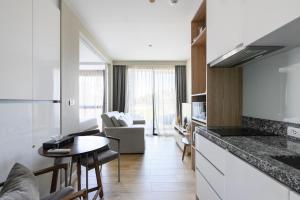 eine Küche und ein Wohnzimmer mit Sofa und Tisch in der Unterkunft Stylish apartment close to Bang Tao beach in Strand Bang Tao