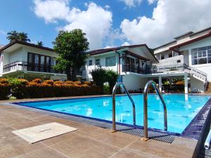 a swimming pool in front of a house at Serenity Tissa in Tissamaharama