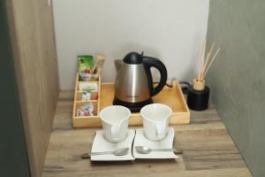 a tea kettle and two spoons on a table at Yoga Luxury Lodge in Thohoyandou
