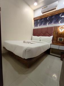 a bedroom with a large bed with a wooden frame at Hotel M R STAY in Mumbai