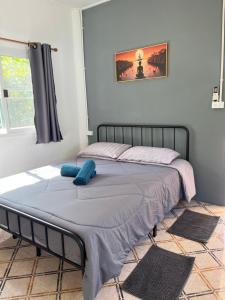 ein Bett in einem Schlafzimmer mit einem blauen Kissen darauf in der Unterkunft Ban Supattra in Ban Khlong Mat + 24 Fotos
