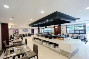 a restaurant with a large kitchen with tables and chairs at GreenTree Inn Jiangsu Suzhou New District Science and Technology College Business Hotel in Suzhou