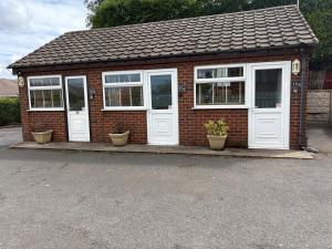 a small brick house with white doors and windows at Central Hotel in Sutton in Ashfield