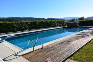 een zwembad met een houten promenade naast bij Casa do Lagar in Alvarenga