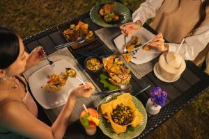 a group of people sitting around a table eating food at Mövenpick Asara Resort & Spa Hua Hin in Hua Hin