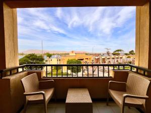 a balcony with chairs and a view of a city at Jewel Luxor Hotel Nile View in Luxor