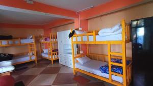 a room with three bunk beds in a room at dreamcatcher homestay in Jāmb