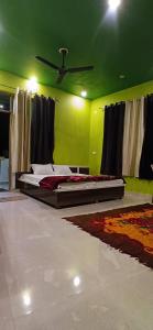 a green room with a bed and a ceiling at dreamcatcher homestay in Jāmb