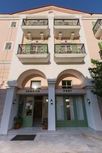 a building with green doors and balconies on it at Samaina Port Hotel in Karlovasi