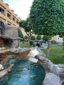 a water feature in a yard with a fountain at Jewel Luxor Hotel Nile View in Luxor