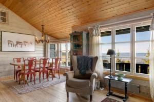 a dining room with a table and chairs and windows at Bekkeblom, family cabin with extension in Hafjell in Hafjell