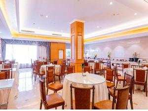 a restaurant with tables and chairs in a room at Vienna International Hotel Shanghai Dishui Lake Lingang Wanda in Shanghai
