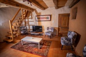 ein Wohnzimmer mit Tisch und Stühlen und einer Treppe in der Unterkunft L'Oustal du Larzac, gîte en Aveyron in La Bastide-Pradines