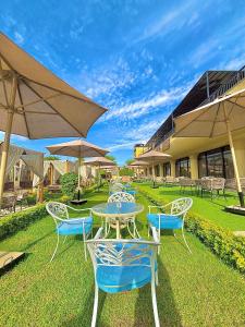 a patio with tables and chairs and umbrellas at Jewel Luxor Hotel Nile View in Luxor