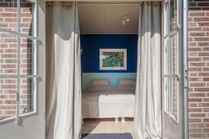 een slaapkamer met een bed met blauwe muren bij Btween Maas & Waal in Druten