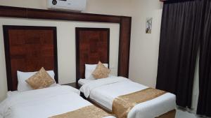 ein Schlafzimmer mit zwei Betten mit weißer Bettwäsche in der Unterkunft أرقى خيال للوحدات السكنية in Chamis Muschait + 30 Fotos