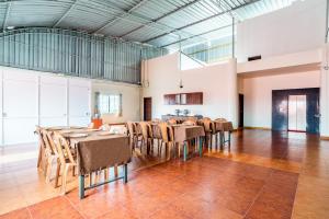 una grande sala da pranzo con tavoli e sedie di Treebo Trend Pappilon Palace a Mangalore