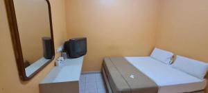 ein kleines Zimmer mit einem Bett und einem Spiegel in der Unterkunft Jamilah Inn BilikXpert in Gua Sai
