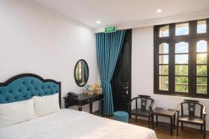 a bedroom with a bed and a desk and a window at Nhật Tân Hotel in Hanoi
