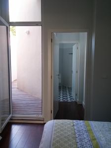 a bedroom with a sliding glass door leading to a bathroom at Oporto Downtown Apartment in Porto
