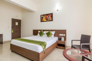 una camera d'albergo con letto e tavolo in vetro di Treebo Trend Pappilon Palace a Mangalore