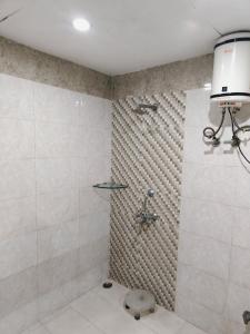 JāmbにあるHotel Royal Plaza At IGI Airportのシャワーとトイレ付きのバスルーム +1枚の写真