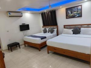 JāmbにあるHotel Royal Plaza At IGI Airportのベッド2台とテレビがあるホテルの部屋