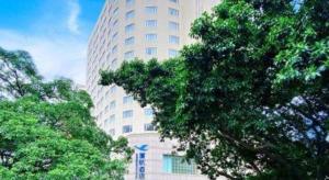 um edifício alto com árvores na frente em Xiamen Airlines Quanzhou Hotel em Quanzhou