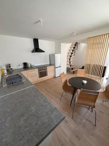una cucina con un tavolo e un tavolo e sedie di Verdun a Savenay