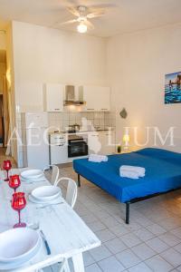 ein Zimmer mit Bett, Tischen und einer Küche in der Unterkunft Pesciolino Bianco in Campese