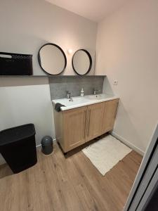 un bagno con lavandino e due specchi sul muro di Verdun a Savenay