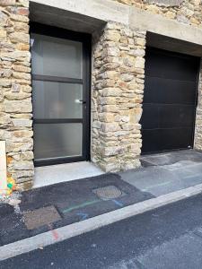 due porte da garage nere in un edificio in pietra di Verdun a Savenay