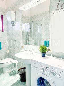 ein Badezimmer mit Waschmaschine und Waschbecken in der Unterkunft Pesciolino Blu in Campese