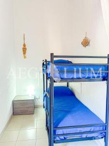 Zimmer mit Etagenbett, 2 Etagenbetten und einem Tisch in der Unterkunft Pesciolino Blu in Campese