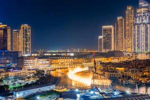 a city lit up at night with tall buildings at Vogue Vacation Homes, Downtown Opera Grand near Burj Khalifa and Dubai Mall, Two Bedroom Apartment with Large Balcony and Access to all Amenities in Dubai +53 photos