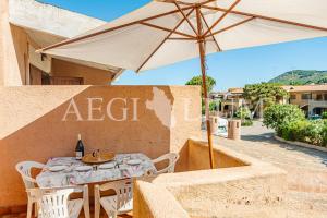 einen Tisch mit einem Regenschirm neben einem Gebäude in der Unterkunft Pesciolino Blu in Campese
