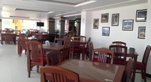 a restaurant with wooden tables and chairs and a dining room at Senesouk Hotel in Vientiane