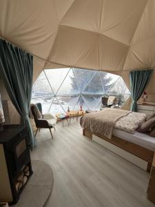 een slaapkamer met een tent met een bed en een open haard bij Glamping Geodome Horní Blatná in Horní Blatná +10 foto's