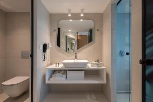 库基尼坎尼奥Arina Beach Resort的浴室里有洗手池、马桶和镜子。