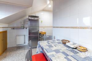 ein Esszimmer mit Tisch und Kühlschrank in der Unterkunft Pensado Para ti in Pozuelo de Alarcón