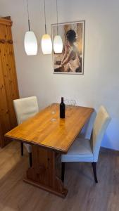 a wooden table with two wine glasses and a painting at Gemütliches Apartment - Kanzelhöhe - Gerlitzen in Treffen
