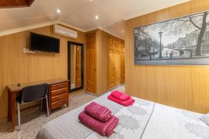 ein Schlafzimmer mit einem Schreibtisch und einem Bett mit zwei rosa Kissen in der Unterkunft Pensado Para ti in Pozuelo de Alarcón